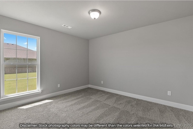 spare room with carpet floors, visible vents, and baseboards