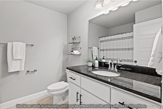 bathroom with wood finish floors, baseboards, vanity, and toilet