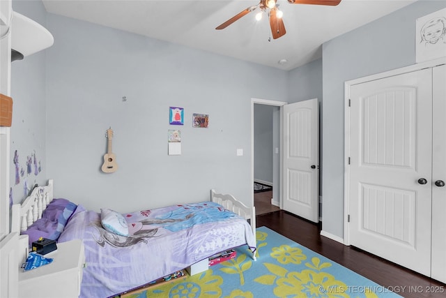 bedroom with ceiling fan, dark wood-type flooring, and a closet