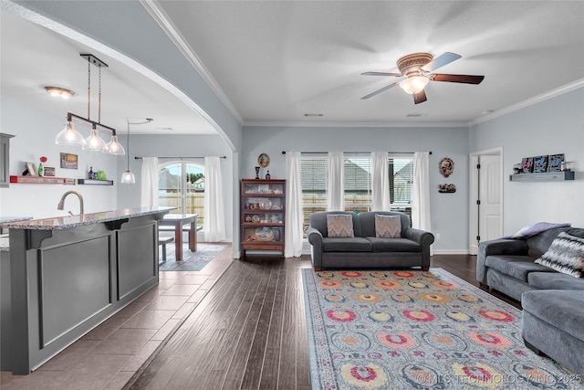 living room with dark hardwood / wood-style flooring, a wealth of natural light, ornamental molding, and ceiling fan