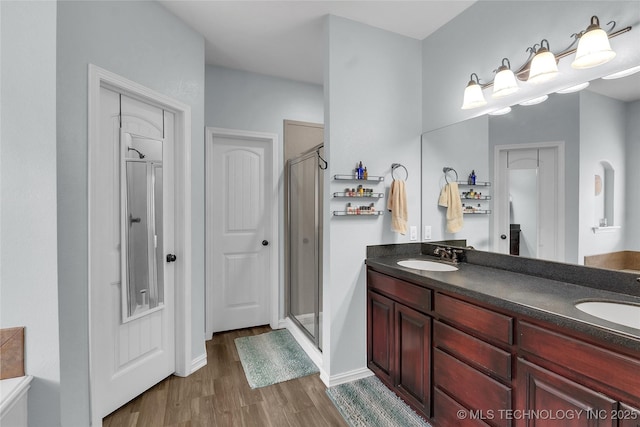 bathroom featuring hardwood / wood-style flooring, vanity, and a shower with shower door