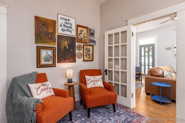 sitting room featuring hardwood / wood-style flooring, ceiling fan, and french doors