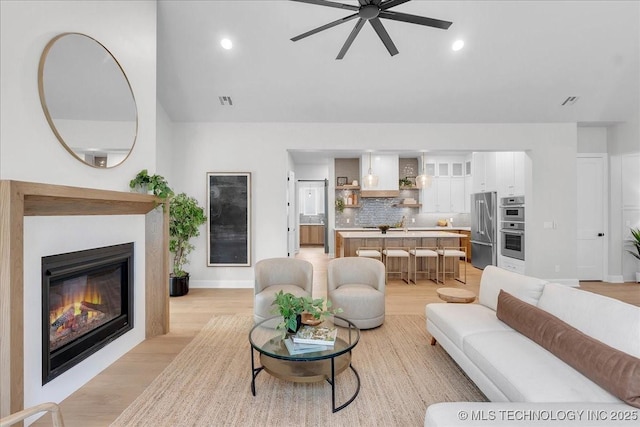 living room with ceiling fan and light hardwood / wood-style floors