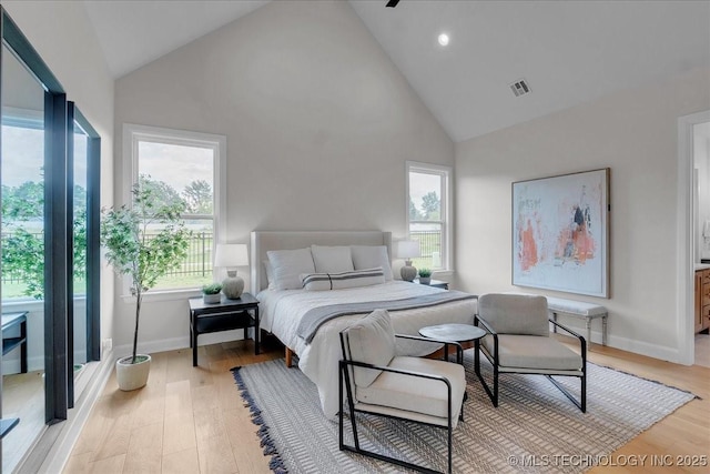 bedroom with multiple windows, light hardwood / wood-style flooring, and high vaulted ceiling