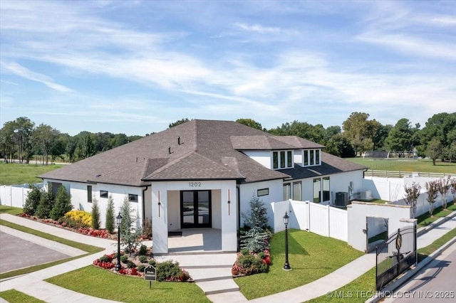 view of front of property featuring a front yard, central AC unit, and french doors