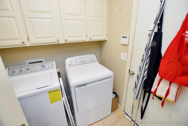 laundry area with cabinets, independent washer and dryer, and light tile patterned floors