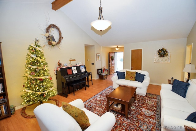 living room featuring vaulted ceiling with beams and light wood-type flooring