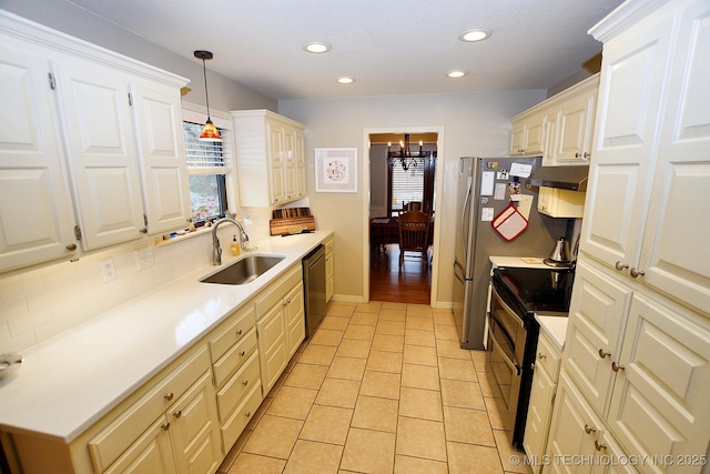 kitchen with sink, hanging light fixtures, an inviting chandelier, light tile patterned floors, and black appliances