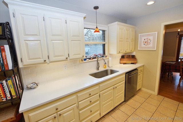 kitchen with pendant lighting, dishwasher, backsplash, sink, and light tile patterned flooring