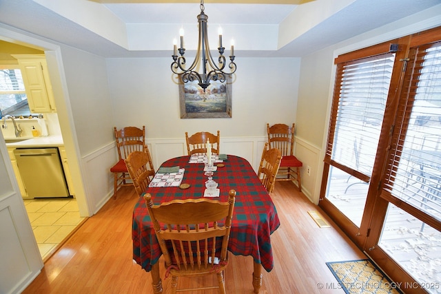 dining space featuring a chandelier, light hardwood / wood-style flooring, and sink