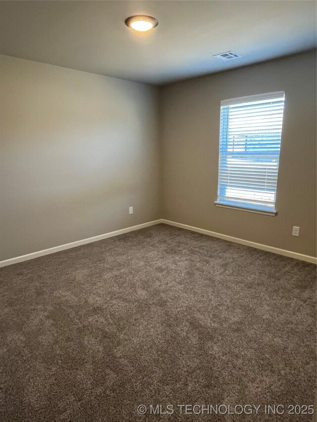 unfurnished room featuring carpet floors, visible vents, and baseboards