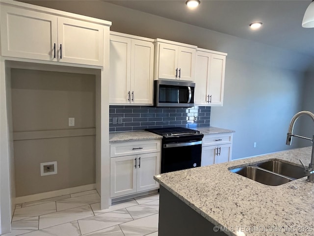 kitchen with a sink, marble finish floor, decorative backsplash, stainless steel microwave, and black gas range oven