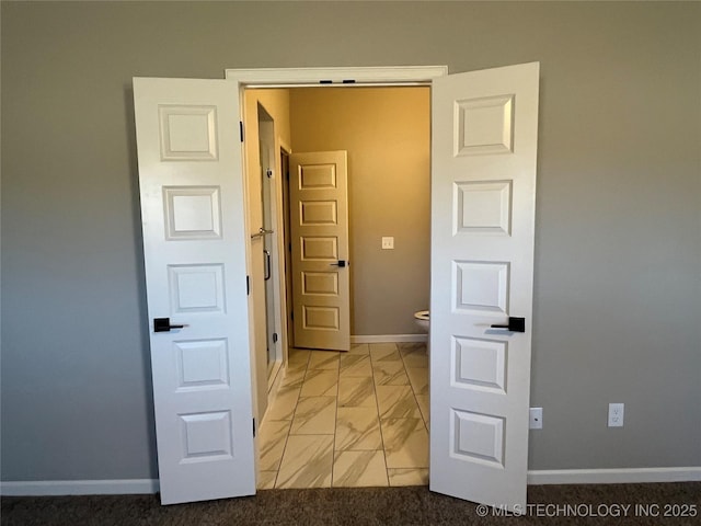 hall featuring marble finish floor and baseboards