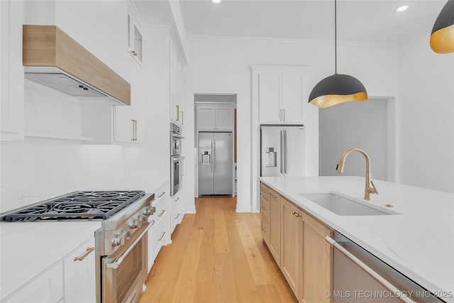 kitchen with pendant lighting, white cabinets, premium appliances, custom exhaust hood, and sink