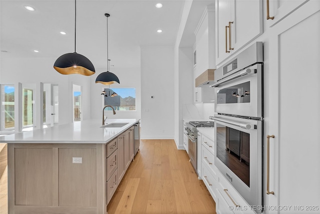 kitchen featuring hanging light fixtures, white cabinets, sink, and a spacious island