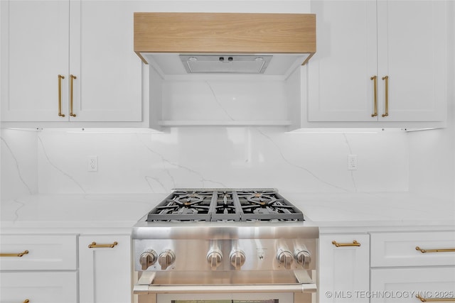 interior details with decorative backsplash, light stone countertops, range, and ventilation hood