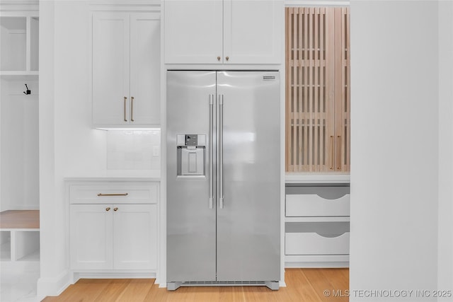 kitchen featuring built in fridge, white cabinetry, and light hardwood / wood-style flooring