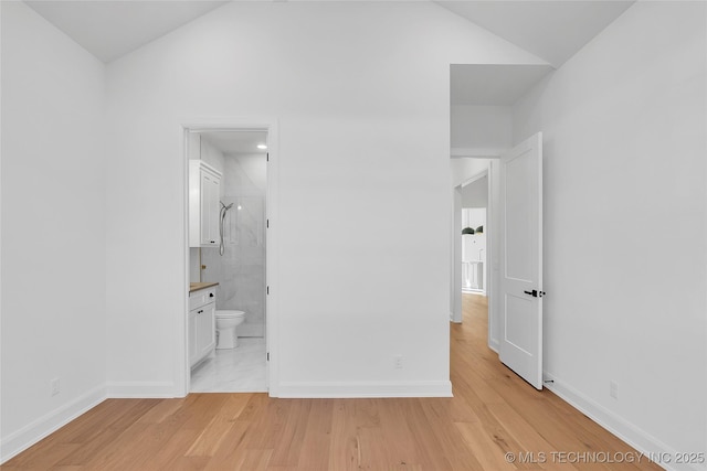 unfurnished bedroom featuring ensuite bathroom and light hardwood / wood-style floors