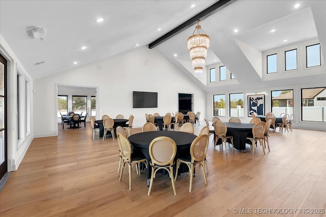 dining area with beam ceiling, high vaulted ceiling, a chandelier, and light hardwood / wood-style floors