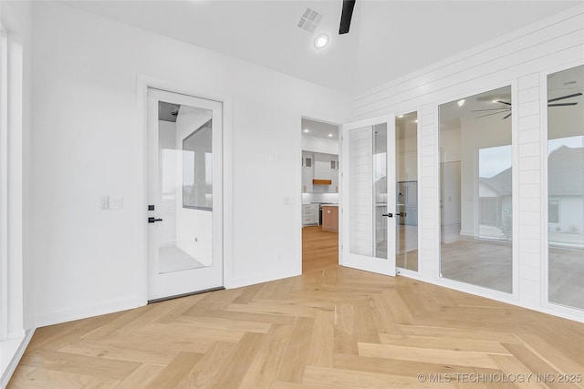 unfurnished room with ceiling fan, parquet flooring, and french doors