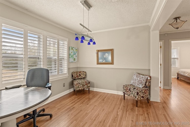 office area featuring a textured ceiling, light wood-type flooring, and crown molding