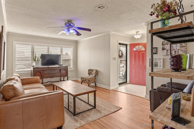 living room featuring a textured ceiling, light hardwood / wood-style floors, ceiling fan, and crown molding