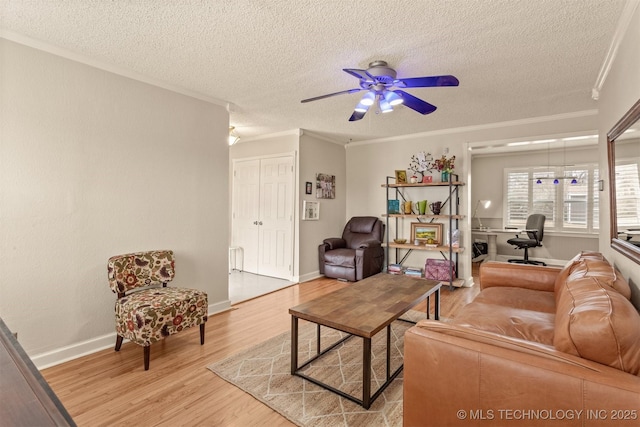 living room with ceiling fan, light hardwood / wood-style floors, ornamental molding, and a textured ceiling