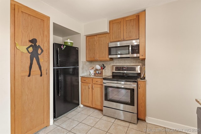 kitchen with tasteful backsplash, light stone countertops, light tile patterned flooring, and stainless steel appliances