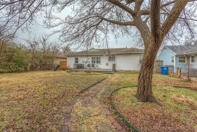 rear view of property featuring a lawn