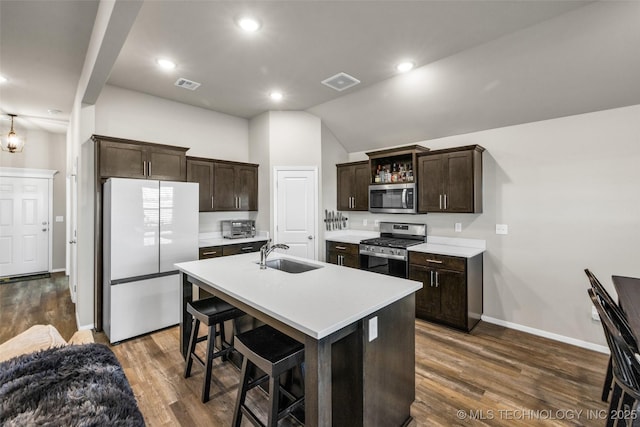 kitchen with appliances with stainless steel finishes, an island with sink, dark wood-type flooring, and sink