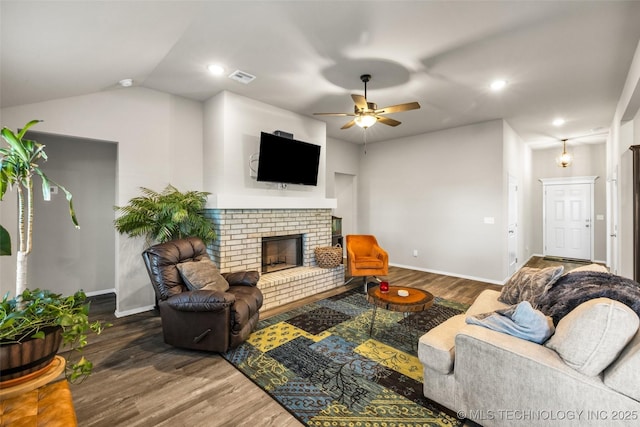 living room featuring a fireplace, dark hardwood / wood-style floors, vaulted ceiling, and ceiling fan