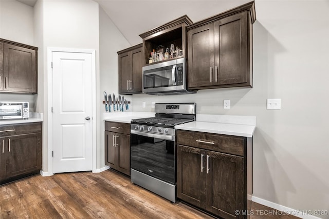 kitchen with dark hardwood / wood-style floors, dark brown cabinetry, and appliances with stainless steel finishes