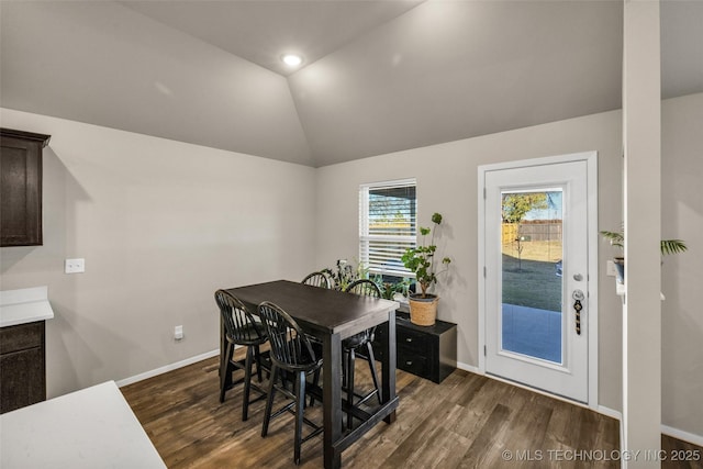 dining space with dark hardwood / wood-style flooring and lofted ceiling