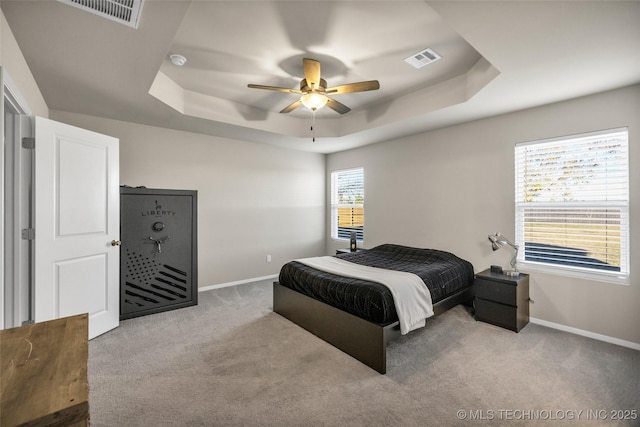 bedroom featuring carpet floors, a tray ceiling, and ceiling fan