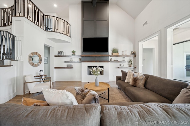 living room with high vaulted ceiling and light wood-type flooring