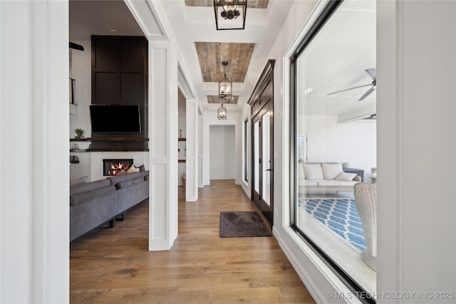 corridor featuring wood-type flooring and a tray ceiling