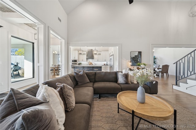 living room with high vaulted ceiling and hardwood / wood-style floors