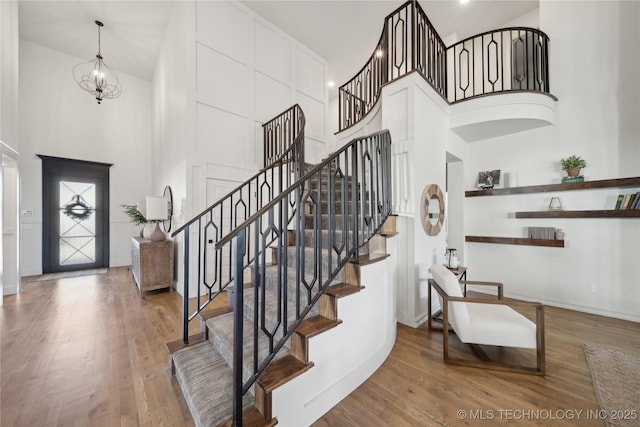 entryway featuring a high ceiling, a chandelier, and hardwood / wood-style floors