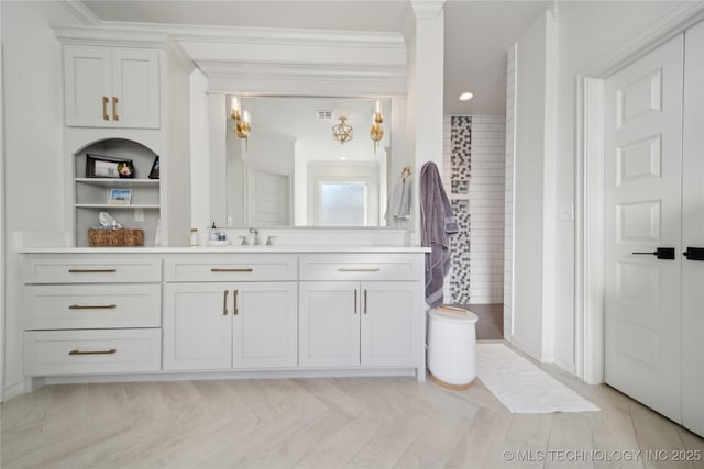 bathroom with parquet floors, ornamental molding, vanity, and built in shelves