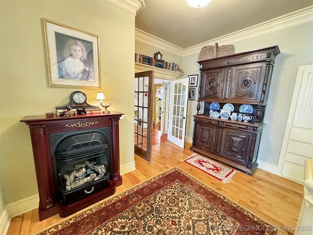 sitting room with ornamental molding, light hardwood / wood-style flooring, and french doors