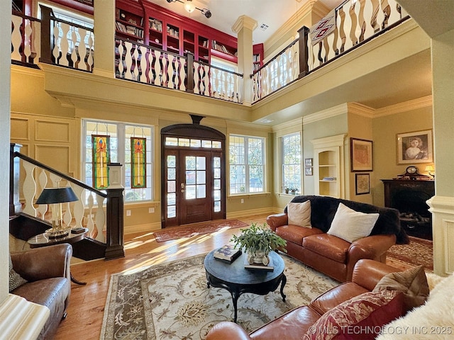 living room featuring ornamental molding, a high ceiling, and hardwood / wood-style flooring