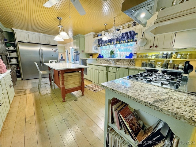 kitchen with stainless steel appliances, light hardwood / wood-style flooring, decorative light fixtures, a kitchen island, and exhaust hood