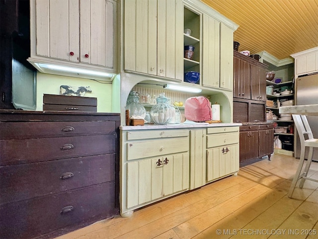 kitchen featuring crown molding, cream cabinetry, and light wood-type flooring