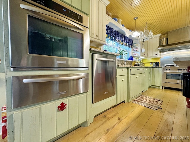 kitchen with a notable chandelier, decorative light fixtures, light wood-type flooring, and stainless steel appliances