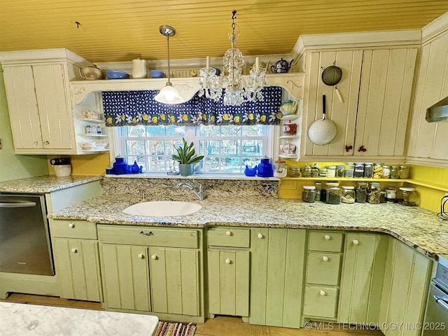 kitchen featuring cream cabinetry, decorative light fixtures, light stone counters, and sink