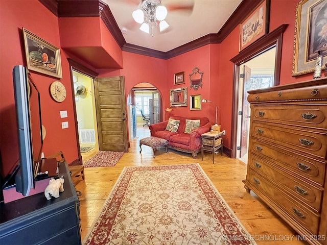 sitting room with light hardwood / wood-style floors, a healthy amount of sunlight, and ornamental molding