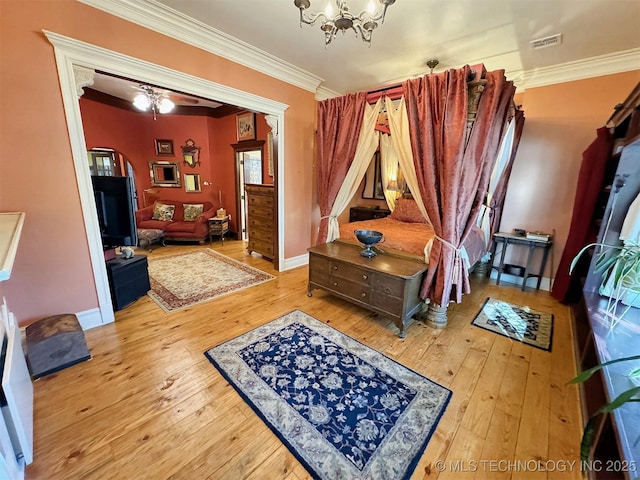 bedroom with hardwood / wood-style floors, a chandelier, and ornamental molding