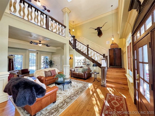 living room with ornamental molding, decorative columns, ceiling fan, and light hardwood / wood-style floors