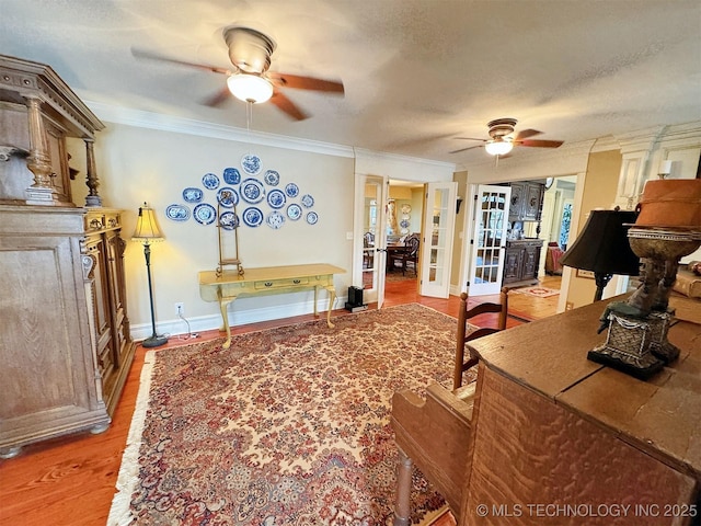 living room with hardwood / wood-style flooring, french doors, a textured ceiling, and ornamental molding