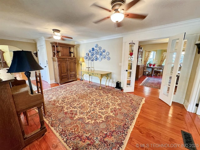 interior space featuring french doors, light hardwood / wood-style floors, ceiling fan, and ornamental molding